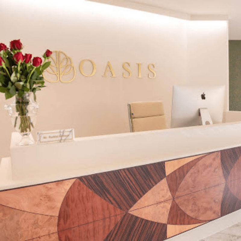 Oasis front desk with computer, desk chair, and roses