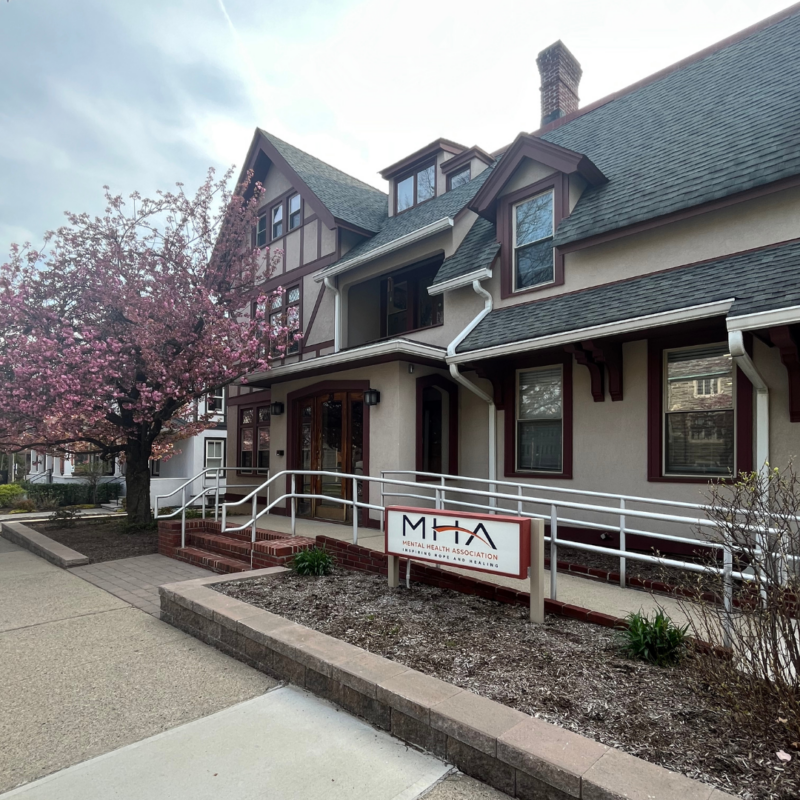 Mental Health Association building with a large pink tree outside and MHA sign