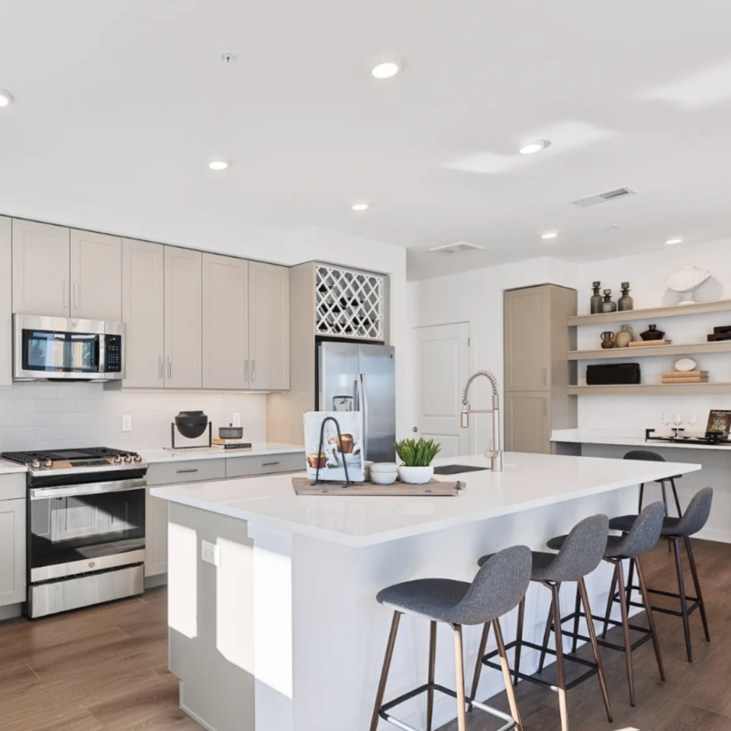 Kitchen in Stonehill residence with island and four grey bar chairs