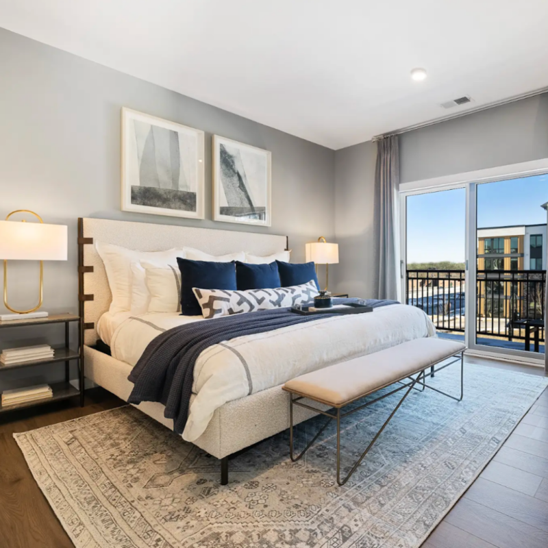 Bedroom in Stone hill residence with bedside table, lamp, and large window