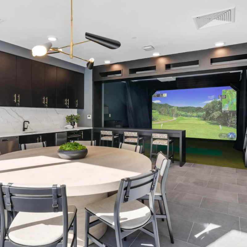 Community room at Stonehill with round table, chairs and large screen