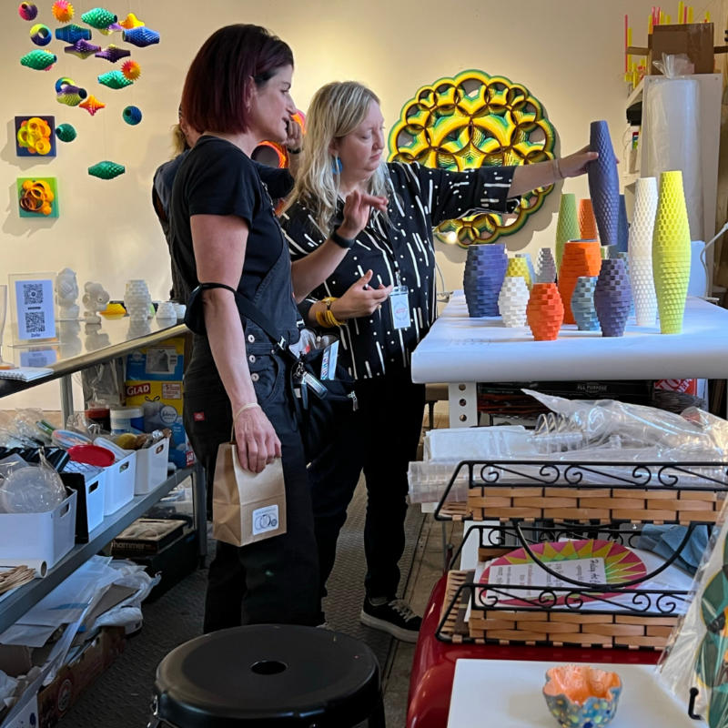 Two people looking at colorful vases