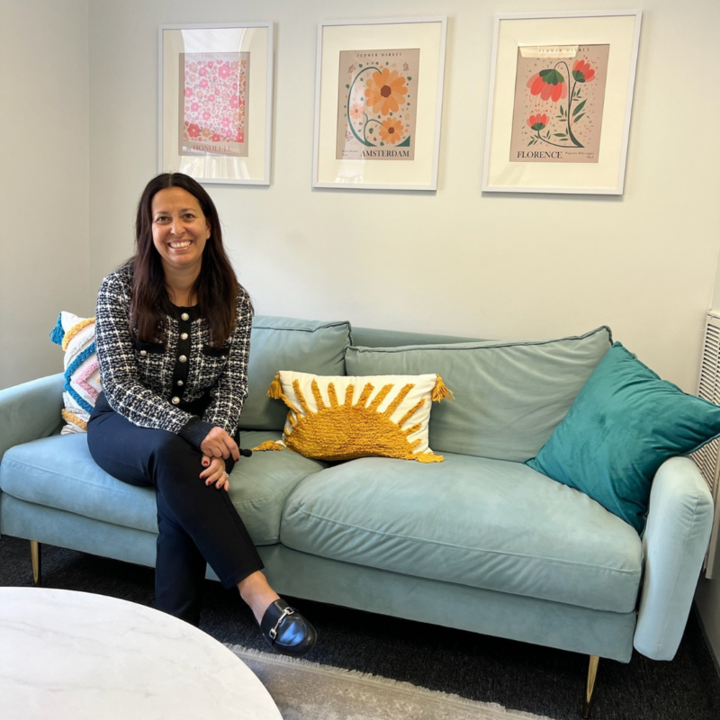 Dr. Keri Wasser sitting on a blue couch