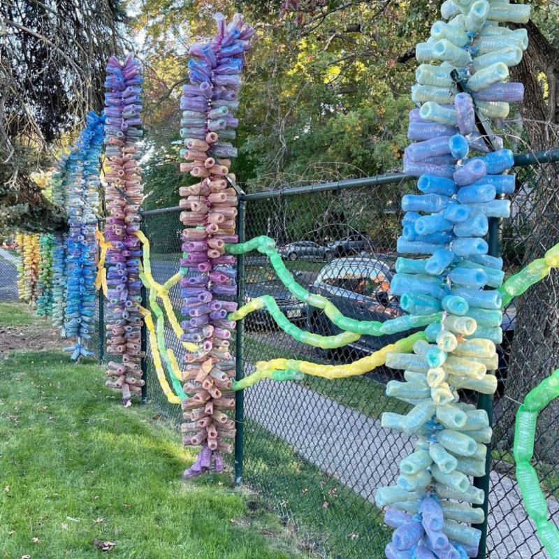 Colorful sculptures attached to a fence at Manufacturers Village